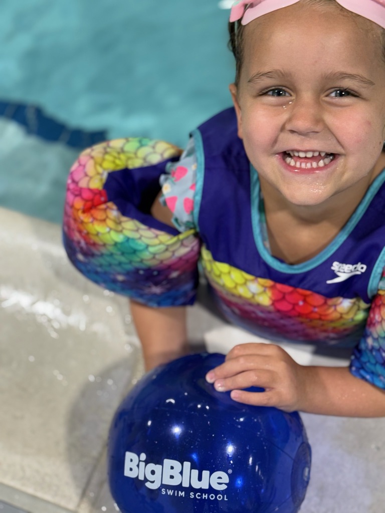 Smiling swimmer holding a Big Blue ball